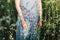 Beautiful girl in light blue linen dress on a summer meadow in sunlight