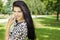 Beautiful girl with long black hair with a smile happy standing in the Park