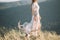 Beautiful girl in long curly white gray dress profile, tulle, veil, nature, mountains, forest, deer skull with horns near the foot