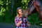 Beautiful girl with long hair on a walk with a horse.