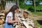 beautiful girl with long hair in white shirt puts firewood in pile. Concept of harvesting firewood for winter.