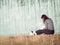 A beautiful girl with long natural black hair sits on the bokeh background of fountain. Back view.