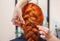 Beautiful girl with long redhair, hairdresser weaves a  braid, close-up in a beauty salon. Professional hair care and creating