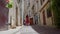 Beautiful girl in long romantic dress runs away on the streets of the old Parisian city. Rear view. Distant view