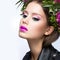 Beautiful girl with a lot of flowers in their hair and bright pink make-up. Spring image. Beauty face.