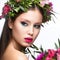 Beautiful girl with a lot of flowers in their hair and bright pink make-up. Spring image. Beauty face.