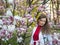 Beautiful girl among magnolia pink blossom sping tree flowers