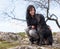 Beautiful girl with mutt black dog on mountains