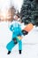 Beautiful girl in overalls on a background of snow, in hands of a snowboard board. Emotions of happiness of pleasure of