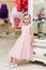 Beautiful girl in a pink dress in store