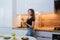 A beautiful girl with a plate of diet salad stands in the kitchen. Woman eating vegetarian salad with herbs