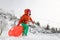 Beautiful girl playing with saucer sled on snow