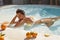 Beautiful Girl At Pool With Citrus Enjoying Summer Sunny Day. Model In Bikini At SPA Resort.