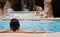 Beautiful Girl Poolside Relaxing by a Waterfall