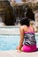 Beautiful Girl Poolside Relaxing by a Waterfall