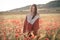 Beautiful girl in a poppy field at sunset. concept of freedom