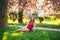 Beautiful girl posing to the photographer against the background of blooming pink trees. Spring. Sakura.