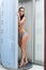 Beautiful girl posing topless in vertical solarium