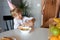 Beautiful girl pours milk into a bowl of cereal