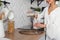 Beautiful girl pours milk from a carafe into a glass, in the stylish cozy kitchen. Healthy eating and diet concept.