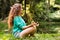 Beautiful girl practices yoga in the morning forest.