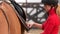 Beautiful girl preparing saddle for riding horse.