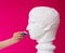 Beautiful girl proposes mouthwash for antique statue