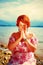 Beautiful girl with radiant red hair in sommer dress in a meditative spiritual gesture of prayer.