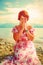 Beautiful girl with radiant red hair in sommer dress in a meditative spiritual gesture of prayer.