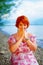 Beautiful girl with radiant red hair in sommer dress in a meditative spiritual gesture of prayer.