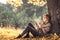 Beautiful girl reading a book in autumn forest