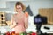 Beautiful girl recording video on camera at kitchen