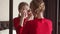 Beautiful Girl in Red Dress Looking in the Mirror - Portrait of a young woman in a room wearing party gown.