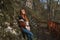 Beautiful girl with red hair leaned on a rock in the park