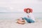 Beautiful girl in a red hat with picnic basket at the summer waterfront.