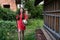 Beautiful girl with red head in dress walking among the garden with shovel in hands, summer holidays in the village