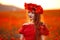 Beautiful girl in red poppy field at sunset. Beuaty makeup. Free