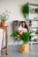 Beautiful girl relaxing at home sitting in armchair in bright room