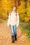 Beautiful girl with rucksack stands in forest