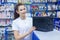 Beautiful girl saleswoman offers the best battery for car in an auto parts store
