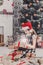 Beautiful girl in santa hat unwrapping christmas presents