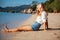 Beautiful Girl in sea style sitting on sand. Travel and Vacation. Freedom Concept.