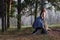 Beautiful girl sits on big stump and poses on wind