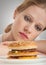 Beautiful girl sits on a diet, sad and hamburger
