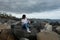 Beautiful girl sitting on beach rocks looking to the sea