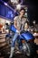 Beautiful girl sitting on a blue motorcycle, city street at night background