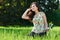 Beautiful girl sitting on a glade in the park, bright sun and sh