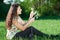 Beautiful girl sitting on a glade in the woods, bright sun and shadows on the grass