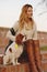 Beautiful girl is sitting with her dog Cavalier King Charles Spaniel on the red brick stairs