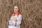 Beautiful girl in a Slavic dress reads a book at a haystack in autumn